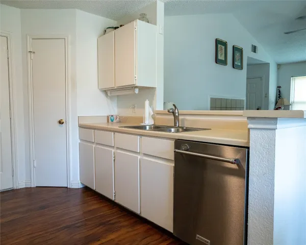 a kitchen with a sink cabinets and wooden floor