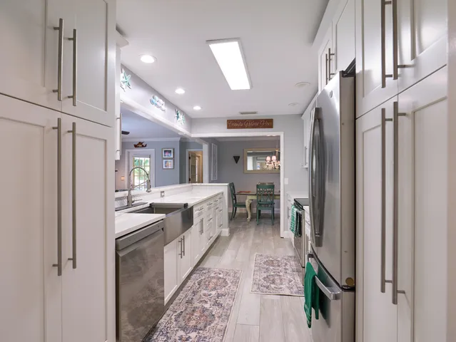 a kitchen with kitchen island a sink appliances and cabinets
