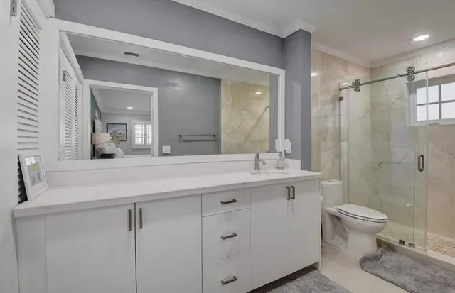a bathroom with a double vanity sink toilet and shower