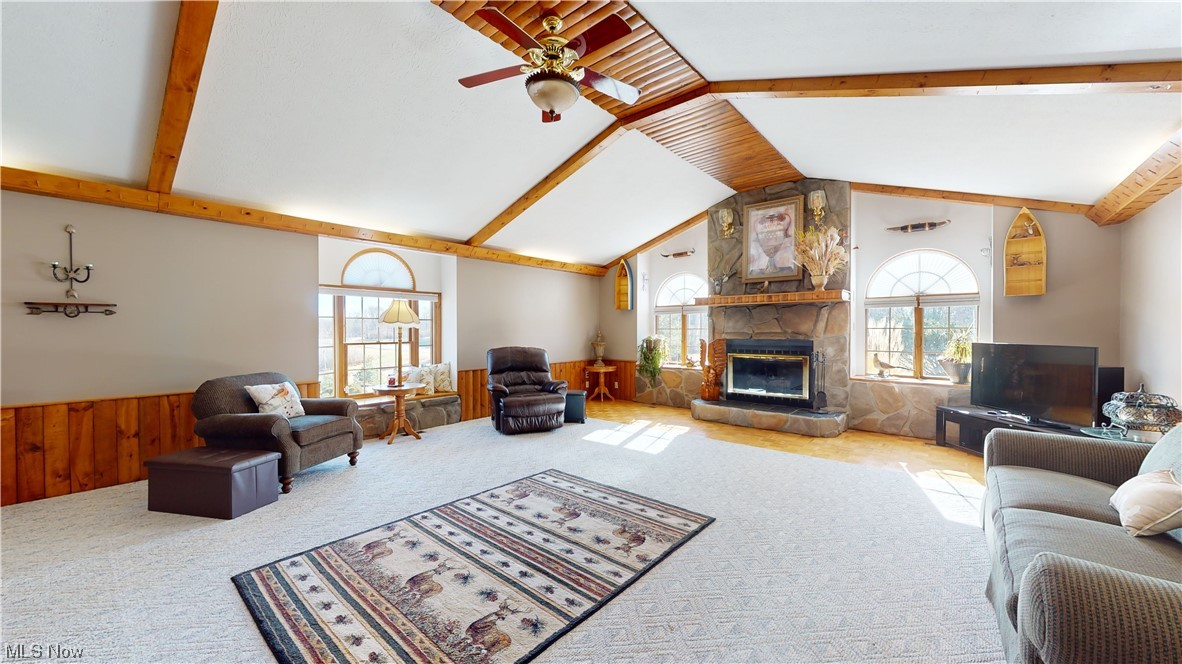 6755 State Rte 5 Ravenna, OH 44266 - Photo 7 of 34 Living room with ceiling fan, lofted ceiling with beams, a fireplace, and light carpet