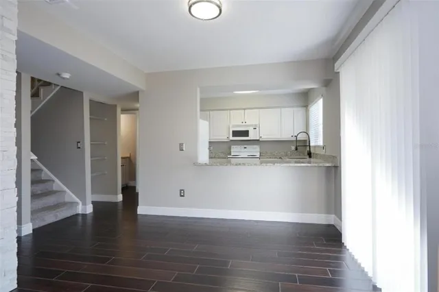 an empty room with wooden floor and a fireplace