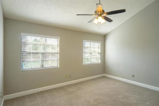 an empty room with a window and a fan