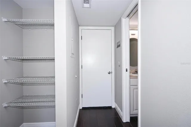 a view of a hallway with closet and wooden floor