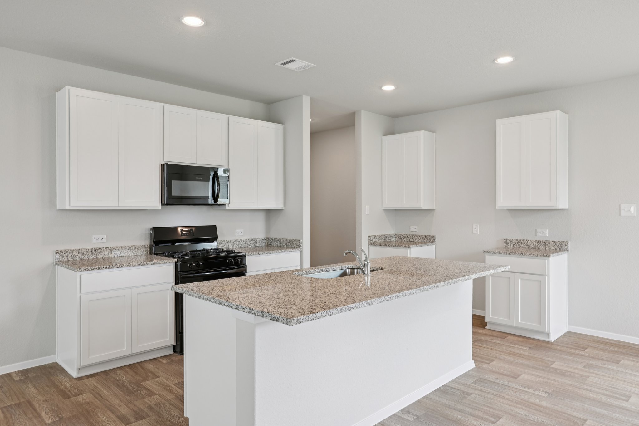 297 Jade Street Maxwell, TX 78656 - Photo 7 of 40 a kitchen with a sink a stove a microwave and cabinets