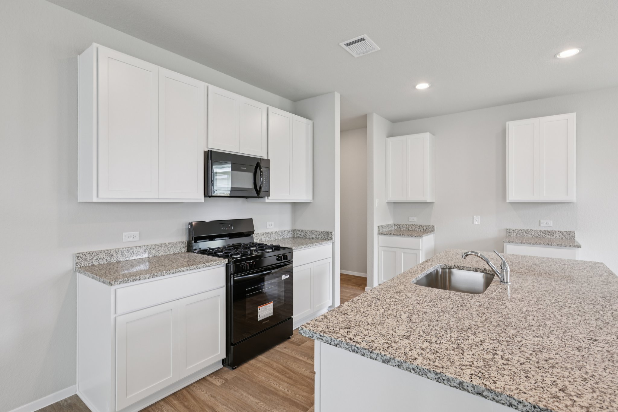 297 Jade Street Maxwell, TX 78656 - Photo 8 of 40 a kitchen with granite countertop white cabinets and stainless steel appliances