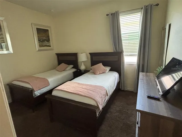 a bedroom with two beds and a flat screen tv