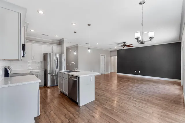 a kitchen with stainless steel appliances granite countertop a sink a stove and a refrigerator