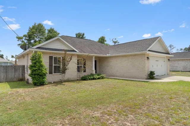 a view of a house with a yard and garage