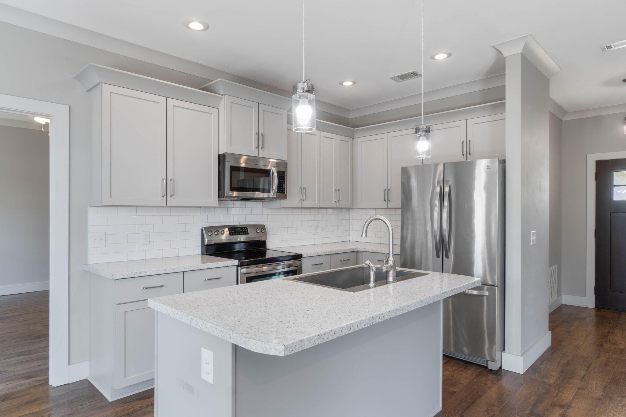 4464 Goldfinch Way Crestview, FL 32539 - Photo 7 of 31 a kitchen with stainless steel appliances a sink a stove a refrigerator and cabinets