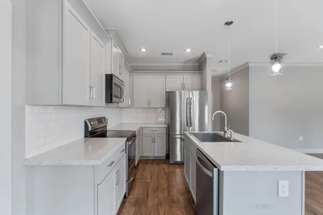 a kitchen with a sink a refrigerator and cabinets