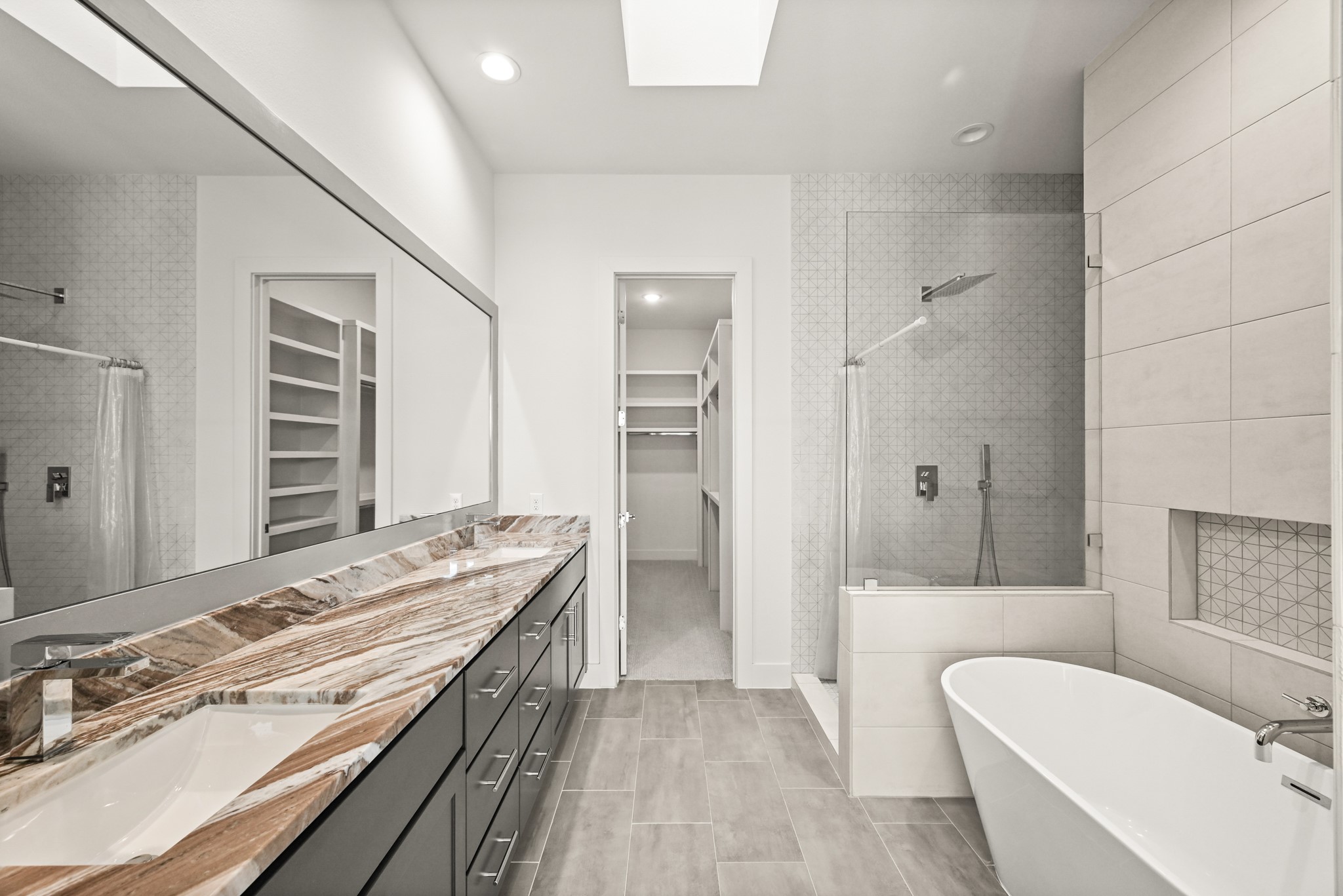 2409 Webster Street Houston, TX 77003 - Photo 12 of 22 a spacious bathroom with a granite countertop tub sink a mirror and a shower