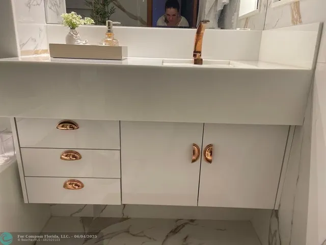 a bathroom with a sink and mirror with toilet