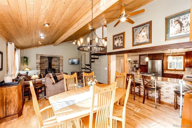a view of a dining hall with couches a dining table and chairs with wooden floor
