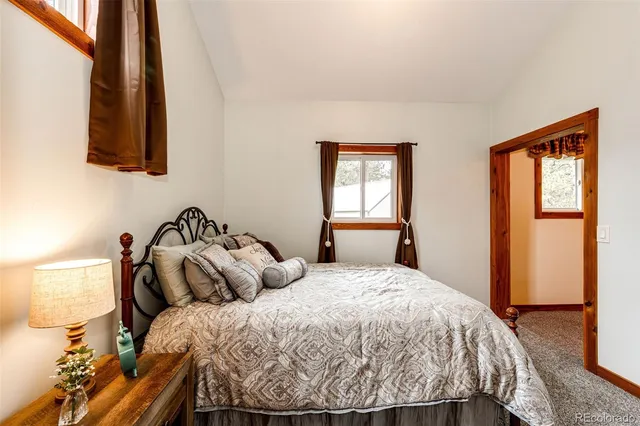 a bed sitting in a bedroom next to a window