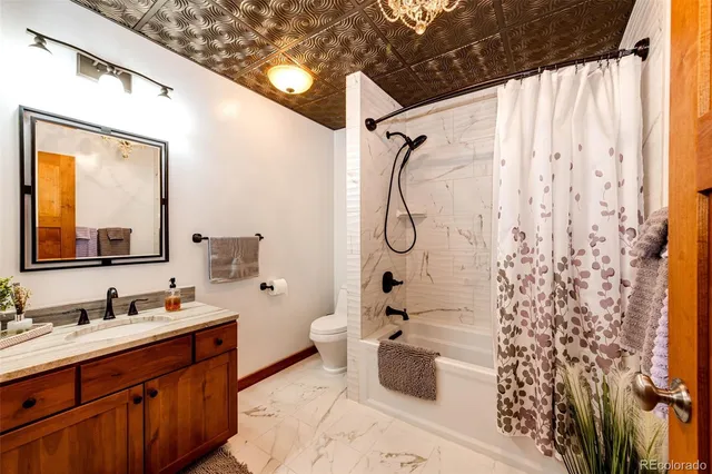 a bathroom with a double vanity sink toilet mirror and shower