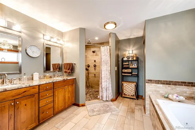 a spacious bathroom with a double vanity sink a large mirror and a shower