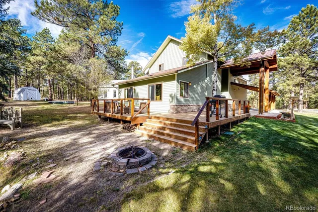 a view of a house with backyard and sitting area