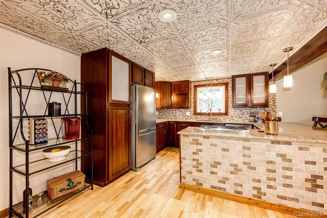 a kitchen with stainless steel appliances kitchen island granite countertop a refrigerator and a stove top oven