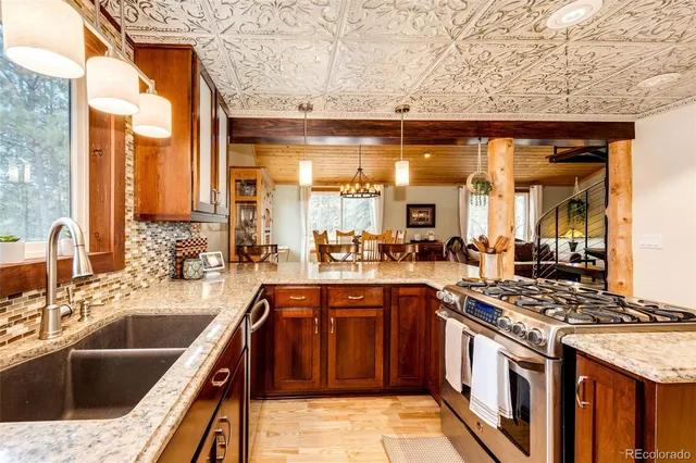 a kitchen with stainless steel appliances granite countertop a sink and a stove