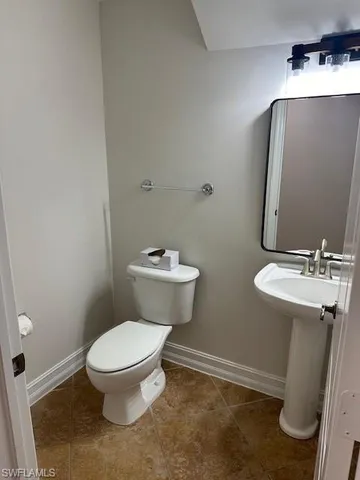 a bathroom with a toilet a sink and mirror