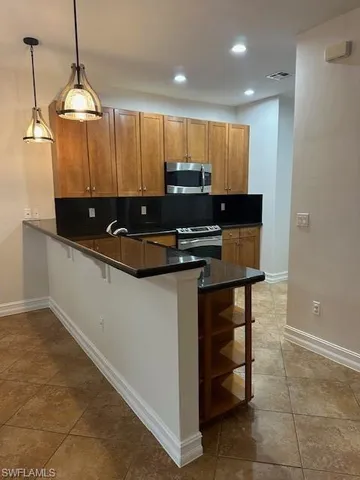 a kitchen with kitchen island granite countertop a sink and a stove