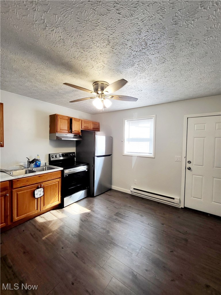631 Root Road Lorain, OH 44052 - Photo 19 of 24 Kitchen with dark wood-type flooring, stainless steel appliances, ceiling fan, sink, and a baseboard heating unit
