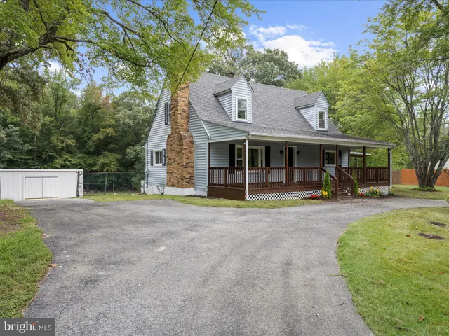 a view of a house with a yard and large tree
