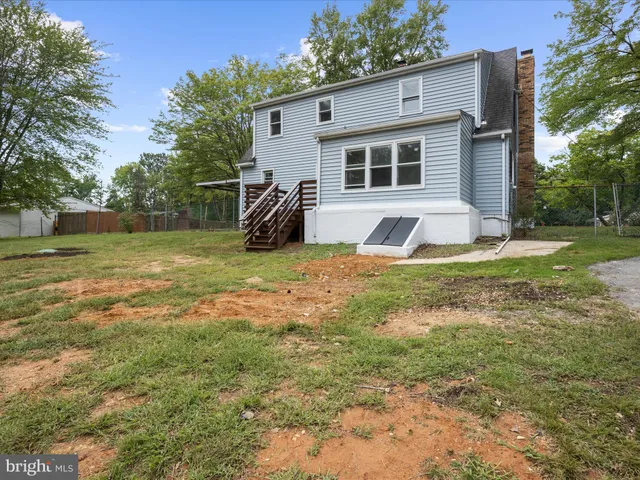 a view of a house with backyard and trees