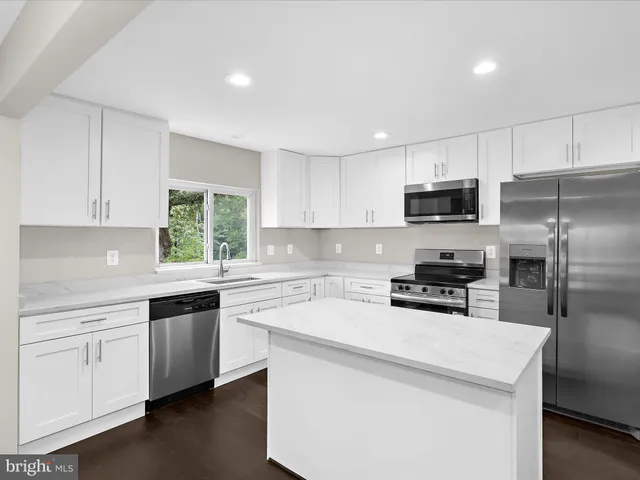 a kitchen with a sink a microwave a stove and refrigerator