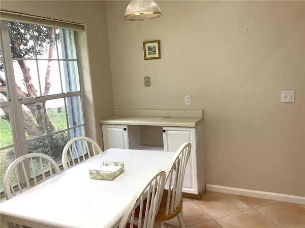 a kitchen with a table chairs and a window