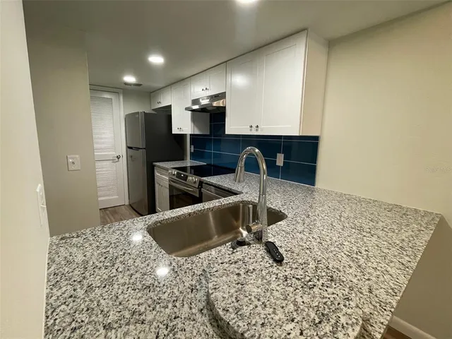 a kitchen with a sink and a stove top oven