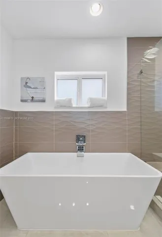 a bathroom with a bathtub a mirror a sink and vanity