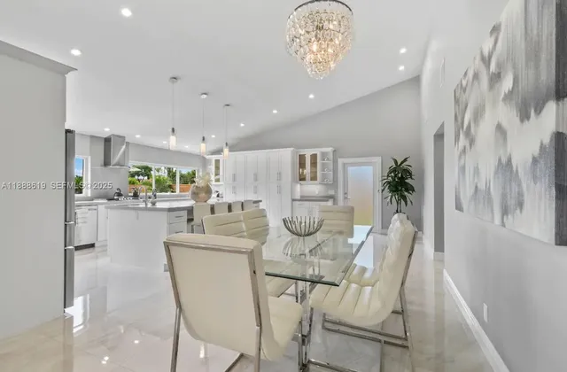 a kitchen with white cabinets and chairs