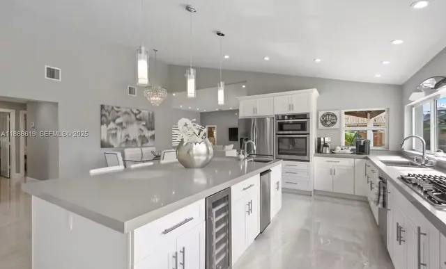a kitchen with stainless steel appliances granite countertop a refrigerator and a sink