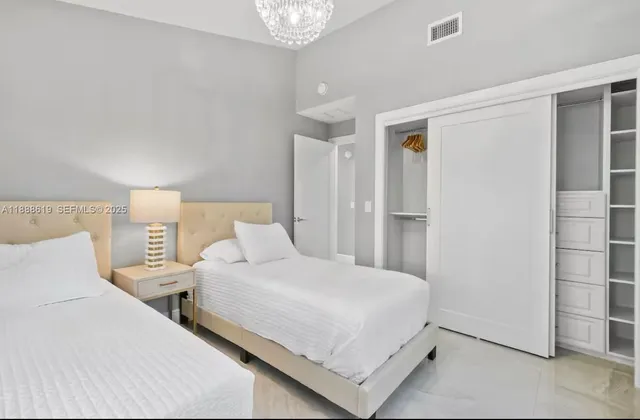 a bedroom with two beds and a window