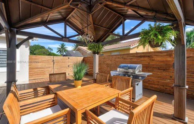 a view of a patio with table and chairs with wooden floor and fence