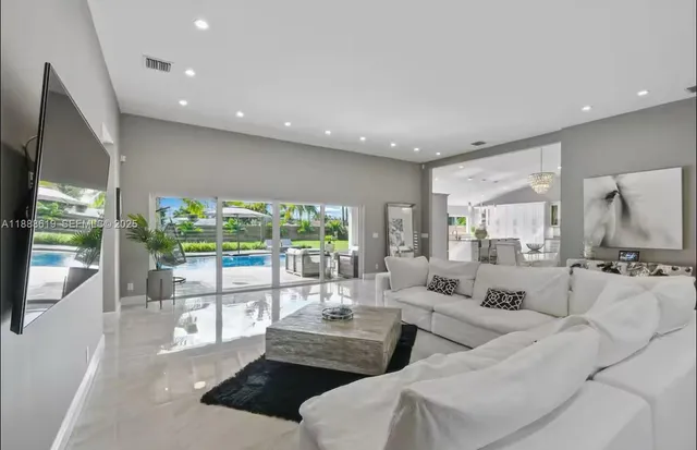 a bedroom with a bed chandelier and a window