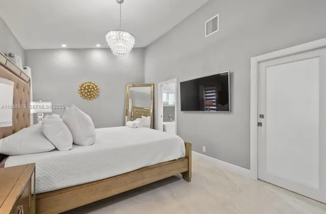 a spacious bedroom with a bed and a flat screen tv