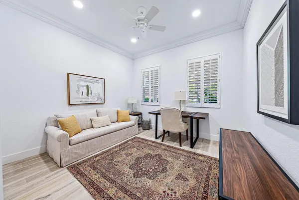 a living room with furniture two window and a wooden floor