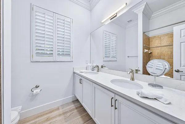 a bathroom with a granite countertop sink a mirror and a shower