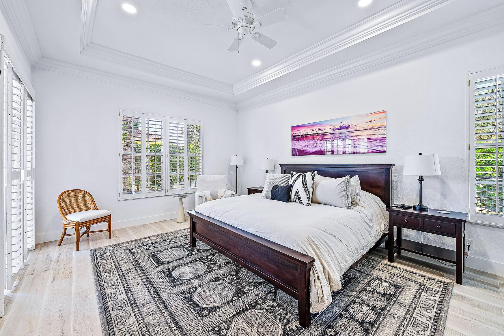 102 Via Santa Cruz Jupiter, FL 33458 - Photo 17 of 30 a bedroom with a large bed a rug and a chair