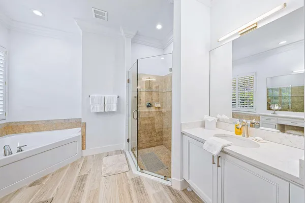 a bathroom with a tub sink and mirror