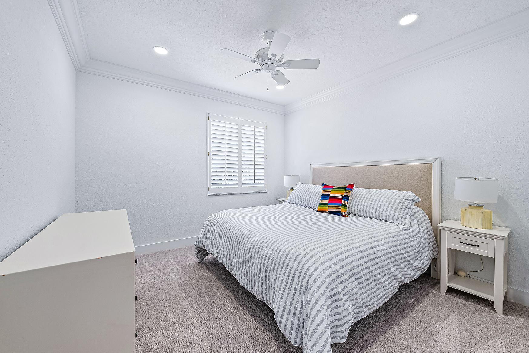 102 Via Santa Cruz Jupiter, FL 33458 - Photo 25 of 30 a bedroom with a bed and a chandelier