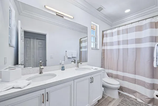 a bathroom with a double vanity sink toilet and a mirror