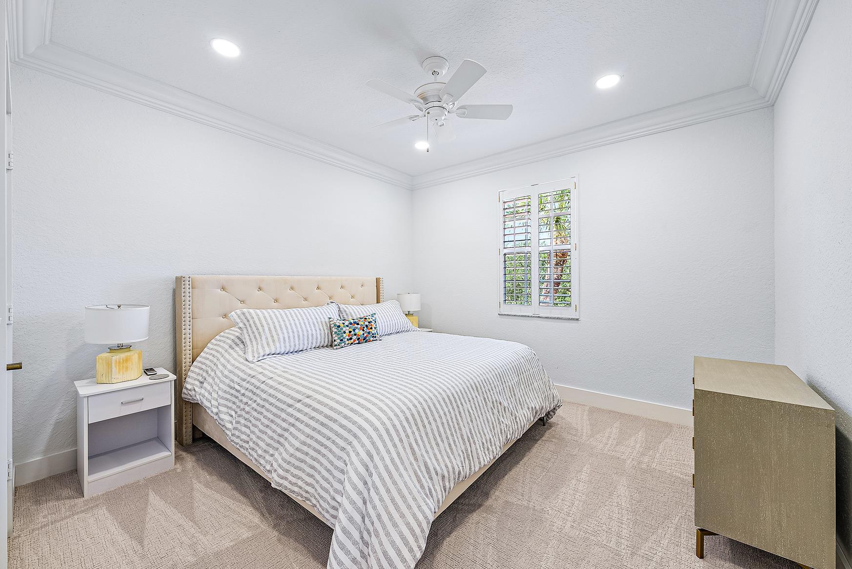 102 Via Santa Cruz Jupiter, FL 33458 - Photo 27 of 30 a bedroom with a large bed and a chandelier