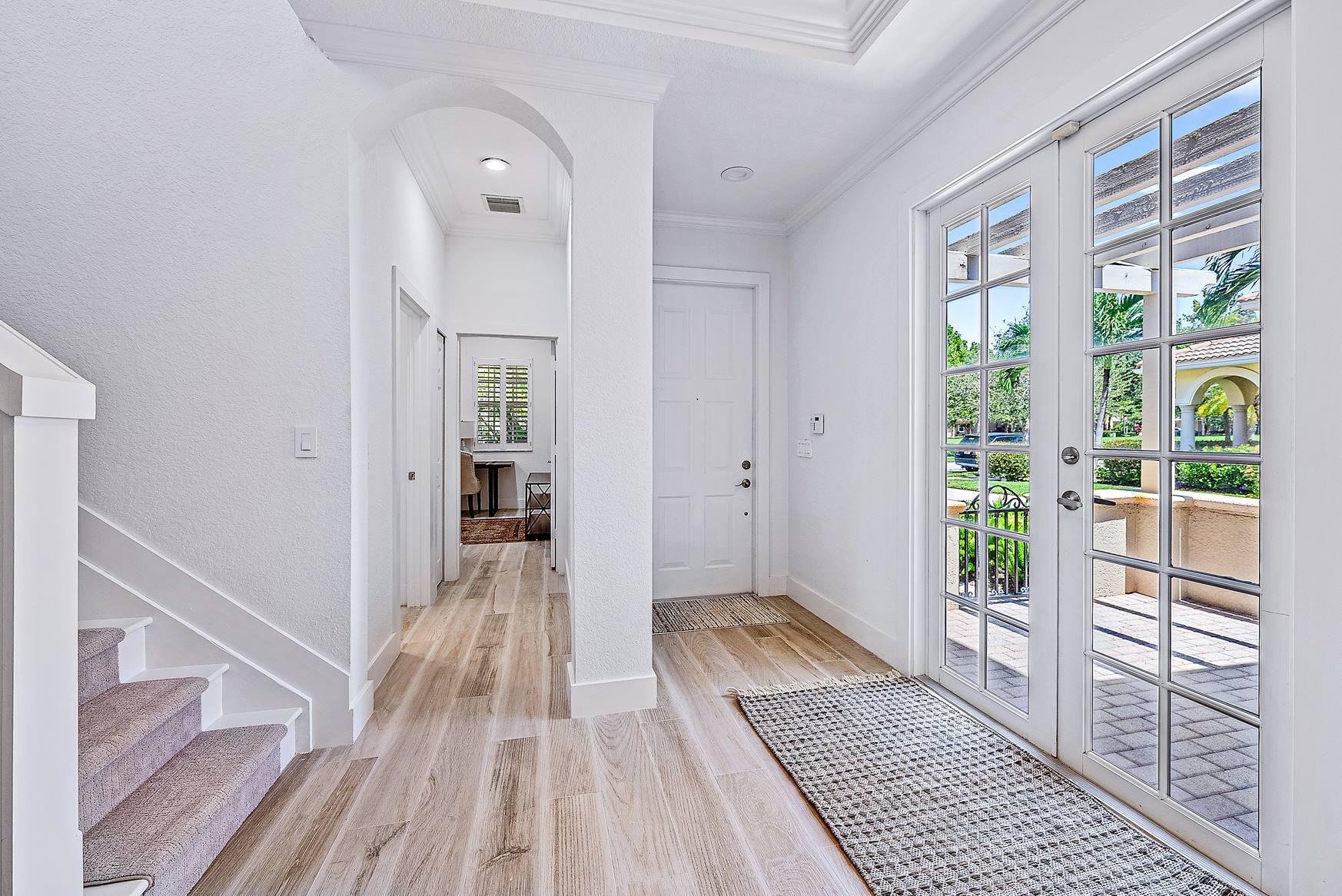 102 Via Santa Cruz Jupiter, FL 33458 - Photo 3 of 30 a view of a hallway view with wooden floor and staircase