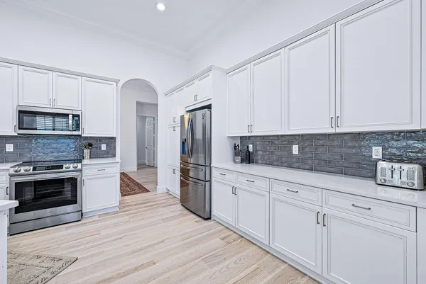 a kitchen with white cabinets and stainless steel appliances