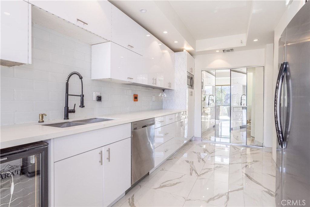 a kitchen with stainless steel appliances a sink cabinets and a refrigerator