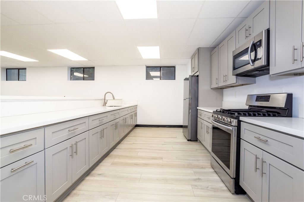 13331 Moorpark Street, Unit 319 Sherman Oaks, CA 91423 - Photo 30 of 46 a kitchen with granite countertop white cabinets and white appliances