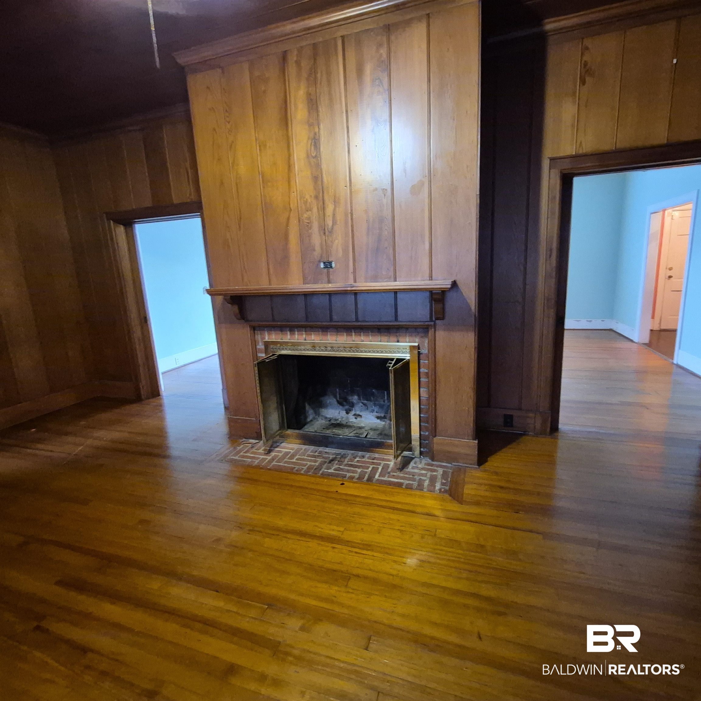 308 Rural Street Evergreen, AL 36401 - Photo 6 of 40 Unfurnished living room with wood walls, dark wood finished floors, and a tiled fireplace